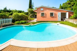 una gran piscina con una casa en el fondo en Villa Magalinette - Maison pour 6 avec piscine, en Mougins
