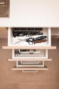a shelf with a bunch of knives and scissors at Plakoures Home in Kounoupidhianá