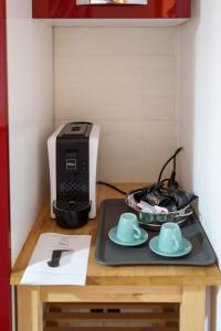 un tavolo con stampante e due tazze e piattini di B&B MELISSA a Silvi Marina