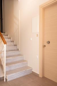 a staircase in a home with a wooden door at Plakoures Home in Kounoupidhianá