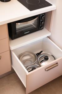 a kitchen drawer with a microwave and pots and pans at Plakoures Home in Kounoupidhianá