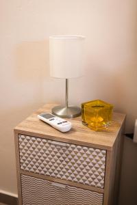 a table with a lamp and a remote control on it at Plakoures Home in Kounoupidhianá
