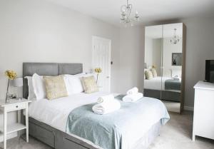 a bedroom with a large bed with towels on it at St Magnus House, Fabulous Harrogate town house in Harrogate