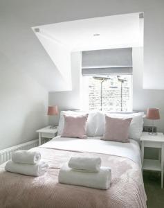 a white bed with two towels on top of it at St Magnus House, Fabulous Harrogate town house in Harrogate +6 photos