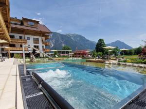 a swimming pool in a resort with mountains in the background at NOVA Moments Boutique Hotel in Pertisau