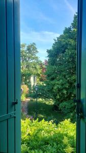 een open raam met uitzicht op een tuin bij Le Mas de Trévouse in Saint-Saturnin-lès-Avignon