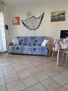 - un salon avec un canapé et du carrelage dans l'établissement Lu Bagnu Castelsardo La Baja dei Tramonti, à Castelsardo