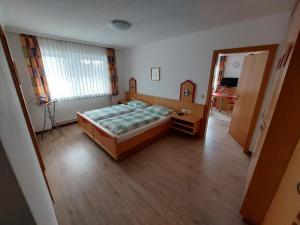 ein kleines Schlafzimmer mit einem Bett und einem Fenster in der Unterkunft Appartementhaus am Brückerl in Bad Füssing