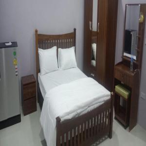 a bedroom with a bed and a dresser and a television at Tulsi Inn at Walking Street in Pattaya South