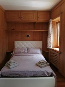a bedroom with a bed with two towels on it at Casa Phoenix Appartamento piano terra immerso nel verde a pochi minuti dalla ciclabile in Pieve di Cadore