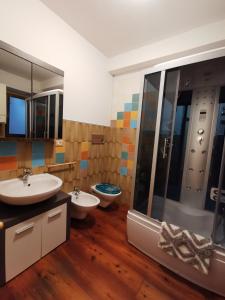 uma casa de banho com 2 lavatórios e um chuveiro em Casa Phoenix Appartamento piano terra immerso nel verde a pochi minuti dalla ciclabile em Pieve di Cadore