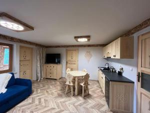 a kitchen with a blue couch and a table in a room at Apartament u Bafiów in Chochołów