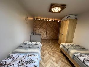 a room with two beds and a wooden floor at Apartament u Bafiów in Chochołów +5 photos