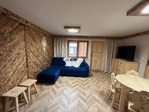a bedroom with a blue bed and a table and chairs at Apartament u Bafiów in Chochołów