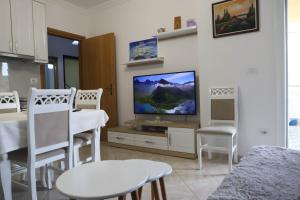 sala de estar con TV, mesa y sillas en Gimi Apartments 2, en Durrës