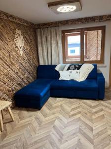 um sofá azul numa sala de estar com uma janela em Apartament u Bafiów em Chochołów