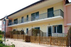 ein Haus mit einem Zaun davor in der Unterkunft Agriturismo Le Collinette in Villanova dʼAlbenga