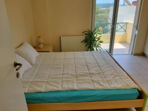 uma cama grande num quarto com varanda em orange em Ialyssos