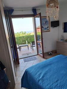 - une chambre avec un lit et une vue sur une terrasse dans l'établissement Lu Bagnu Castelsardo La Baja dei Tramonti, à Castelsardo