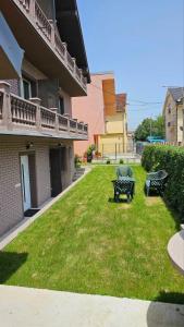 um pátio com uma mesa e cadeiras num quintal em Garden apartmani em Jagodina