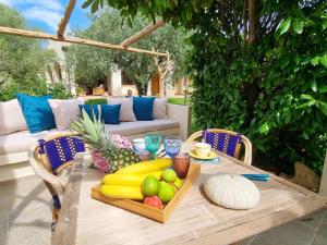 - une table en bois avec un plateau de fruits dans l'établissement STAZZO SAN TEODORO IL GINEPRO, à San Teodoro