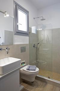 a bathroom with a sink and a toilet and a shower at Naxos King Villa in Galanádhon