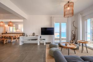 a living room with a couch and a tv at La Villa Havgas in Elounda +48 photos