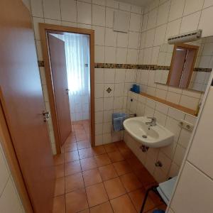 małą łazienkę z umywalką i lustrem. w obiekcie Appartementhaus am Brückerl w mieście Bad Füssing