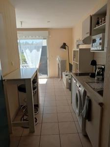 uma cozinha com um lavatório e um fogão forno superior em Studio sur la plage des Dagueys em Libourne