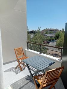 two chairs and a table on a balcony at Studio sur la plage des Dagueys in Libourne