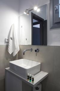 y baño con lavabo blanco y espejo. en Naxos King Villa en Galanádhon