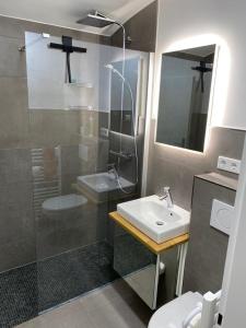 La salle de bains est pourvue d'un lavabo et d'une douche. dans l'établissement Apartment Perle am See - Wohnen auf Zeit - Homeoffice - nah am See - buchbar ab 28 Nächte, à Schliersee