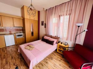 a bedroom with a large bed and a red couch at Studio in the Center in Kavala
