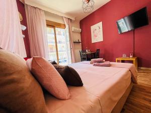 a bedroom with a large bed with a red wall at Studio in the Center in Kavala