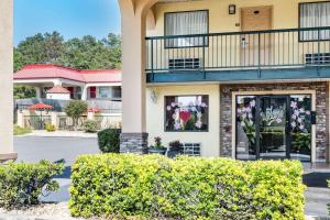 a building with a balcony and flowers in the windows at Days Inn by Wyndham Macon I-475 in Macon