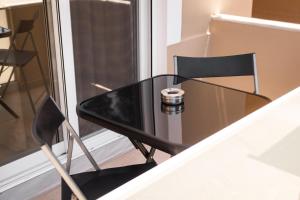 a black table and chair next to a window at Plakoures Home in Kounoupidhianá