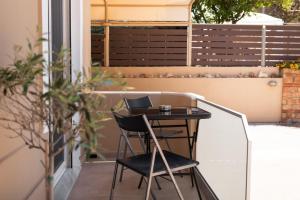 a small table on a balcony with a laptop on it at Plakoures Home in Kounoupidhianá