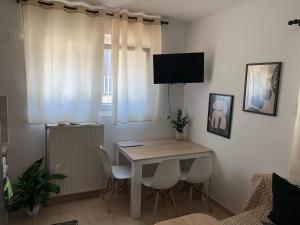 a room with a table and a television on a wall at One Bedroom Flat 250m from Sea, Nea Chili in Alexandroupoli