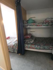 38m2,La Mongie Tourmalet,4/6Pers في بانيير-دوبيغور: غرفة نوم مع سرير وسرير بطابقين
