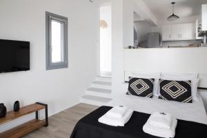 a white room with a bed and a tv at Naxos King Villa in Galanádhon