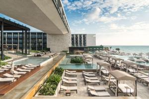 un complejo con piscina, sillas y el océano en Grand Hyatt Playa del Carmen Resort, en Playa del Carmen