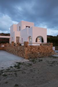a house with a stone wall in front of it at Naxos King Villa in Galanádhon
