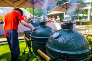 un hombre de pie junto a una parrilla bbq en Hotel Dolce La Hulpe Brussels, en La Hulpe