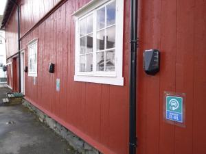 un edificio rojo con una ventana y una señal en él en Grong Gård Guesthouse en Grong