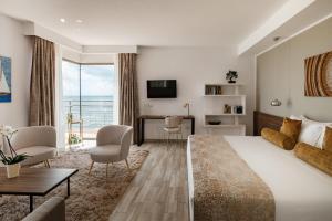 a hotel room with a large bed and a desk at 1926 Le Soleil Hotel & Spa in Sliema