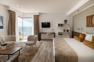 斯利马1926 Le Soleil Hotel & Spa的配有一张大床和一张书桌的酒店房间