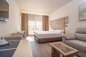 a hotel room with a bed and a couch at Aljarafe Suites by QHotels in Gelves