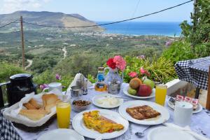 una mesa con platos de comida y vistas al océano en Villa Kapasa, en Mathés