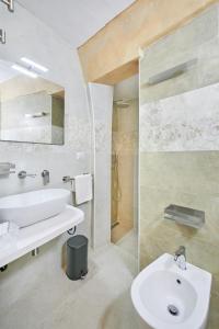 a white bathroom with a sink and a shower at Centro Storico Rooms in Gallipoli