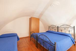 a bedroom with a blue bed in a white room at Centro Storico Rooms in Gallipoli